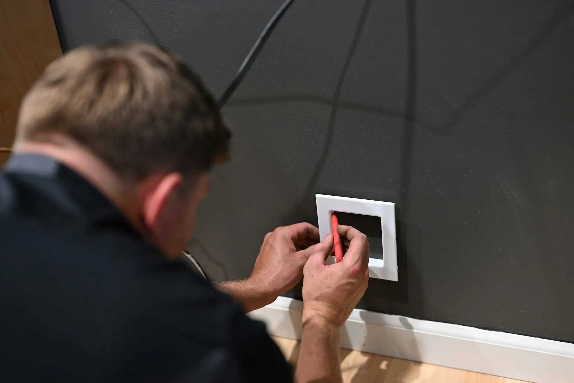 Electrician replacing a light switch on a wall