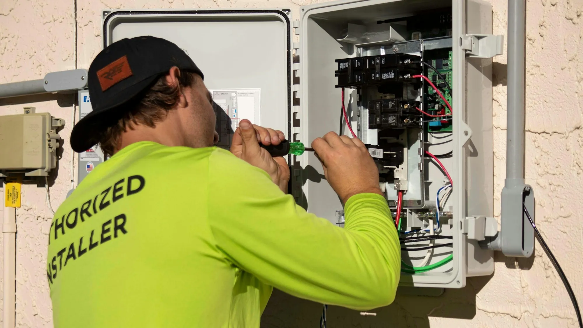 Electrician working on an electrical panel with a screwdriver